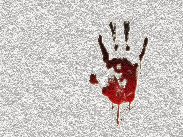 Picture of the shape of and hand with blood on a wall